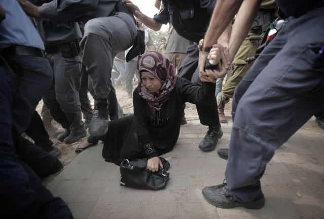 A Palestinian activist is arrested by Israeli soldiers as dozens of Palestinians block the entrance to branch of the Rami Levy supermarket opened in Shaar Binyamin close to the city of Ramallah in the Israeli occupied Palestinian West Bank on October 24, 2012, as the protesters called for a boycott of goods being produced in the Jewish Settlement. (Photo by Ahmad Gharabli/AFP Photo)