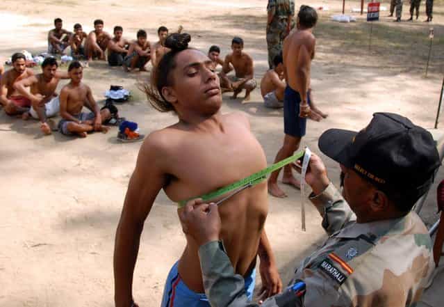 A potential Indian Army recruit has his chest measured during a physical fitness test at an Army recruitment rally at Kapurthala, around 20 km from Jalandhar on October 17, 2012. The Indian Army is a voluntary service and the world's largest standing volunteer army, with over a million active personnel and just under a million in reserve. (Photo by Sahmmi Mehra/AFP Photo)
