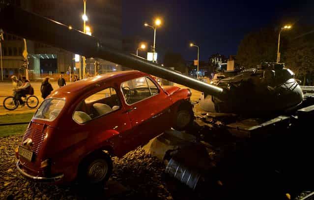 An installation shows a little car running over a tank in Osijek, Croatia, October 16, 2012. The installation commemorates an event from the 1991 conflict when a Yugoslav army tank ran over a similar car intentionally placed in front of it. (Photo by Darko Bandic/Associated Press)