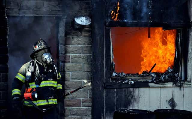 A firefighter works to extinguish a fire that destroyed an apartment building in Harwood near Hazleton, Pennsylvania, October 16, 2012. Four people's homes were devastated in the blaze which is under investigation. (Photo by Ellen F. O'Connell/Hazleton Standard-Speaker)