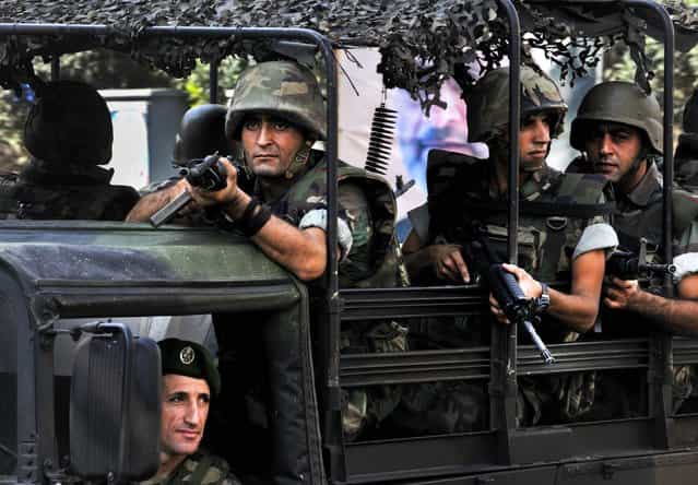 Lebanese Army soldiers patrol a neighborhood after clashes between Sunni and Shiite gunmen in Beirut October 22, 2012. Troops began closing roads to force gunmen out of the city following the funeral of Lebanese Brig. Gen. Wissam al-Hassan, who was killed in a car bomb in east Beirut last week. (Photo by Ahmad Omar/Associated Press)