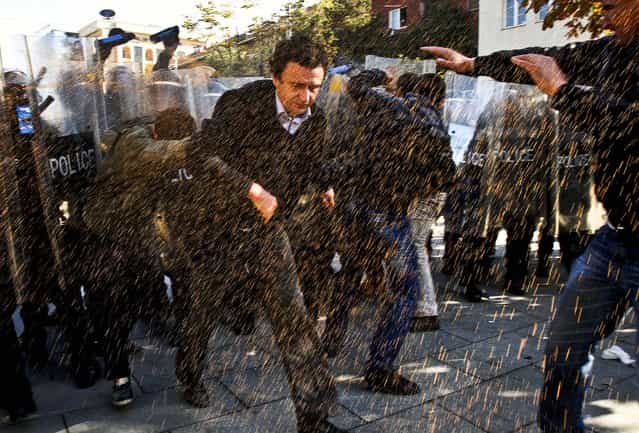 Opposition party leader Albin Kurti, runs through pepper spray used by police to disperse a crowd of anti-Serbia demonstrators protesting a meeting between Prime Minister Hashim Thaci and Serbian leader Ivica Dacic. in Pristina October 22, 2012. (Photo by Visar Kryeziu/Associated Press)