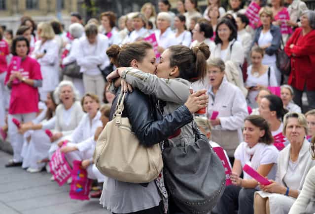 Two women kiss in front of people taking part in a demonstration called by the [Alliance VITA] association against gay marriage and adoption by same-sex couples on October 23, 2012 in Marseille, southeastern France. France on October 10 named October 31 as the date when a draft law authorising gay marriage will be approved by government ministers, amid mounting opposition to the proposed legislation. (Photo by Gerard Julien/AFP Photo)