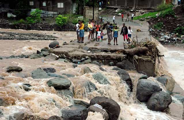 Residents stand on a bridge that was previously destroyed in 2008 by Tropical Storm Gustav, while watching Hope River swell in the village of Kintyre, near Kingston, Jamaica, after the passing of Hurricane Sandy on Thursday. Sandy, which made landfall Wednesday afternoon near Kingston, crossed over Jamaica killing an elderly man when a boulder crashed into his clapboard house, police said. (Photo by Collin Reid/Associated Press)