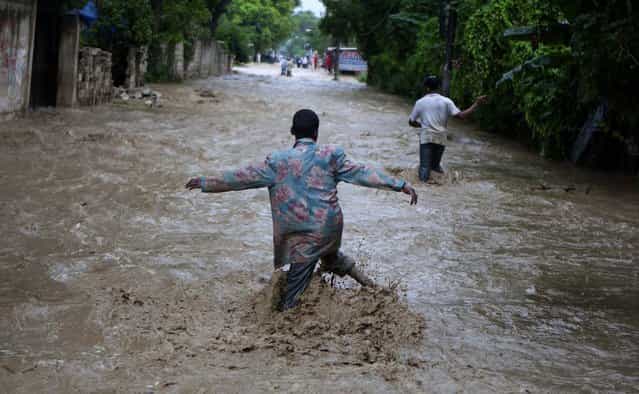 Residents wade through a street flooded by heavy rains from Hurricane Sandy in Port-au-Prince, Haiti. (Photo by Dieu Nalio Chery/Associated Press)