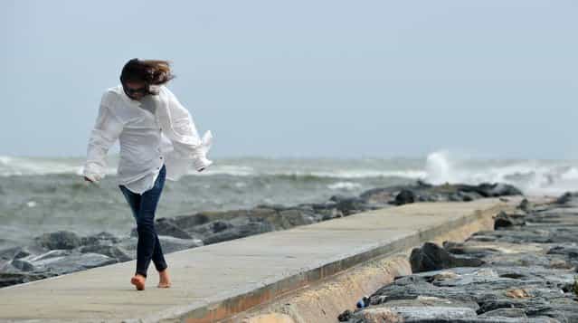 Alison Reed pushes against the wind Friday afternoon on the north jetty in Palm Beach. (Photo by Jeffrey Langlois/Palm Beach Daily News)