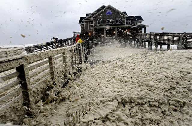 High winds blow sea foam onto Jeanette's Pier in Nags Head, North Carolina as wind and rain from Hurricane Sandy move into the area on Sunday. (Photo by Gerry Broome/Associated Press)