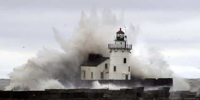 Waves pound a lighthouse on the shores of Lake Erie near Cleveland as high winds spinning off the edge of superstorm Sandy took a vicious swipe at northeast Ohio early Tuesday. (Photo by Tony Dejak/Associated Press)