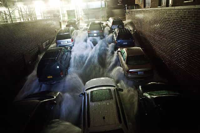 Rising water, caused by Hurricane Sandy, rushes into a subterranian parking garage on October 29, 2012, in the Financial District of New York, United States. Hurricane Sandy, which threatens 50 million people in the eastern third of the U.S., is expected to bring days of rain, high winds and possibly heavy snow. New York Governor Andrew Cuomo announced the closure of all New York City will bus, subway and commuter rail service as of Sunday evening. (Photo by Andrew Burton/AFP Photo)