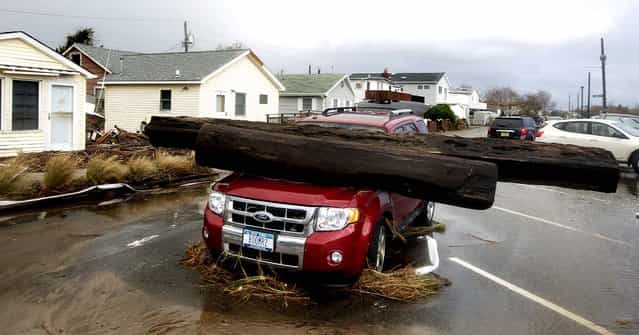 A log rests on a vehicle damaged by superstorm Sandy at Breezy Point. (Photo by Frank Franklin II/Associated Press)