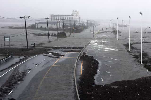 U.S. Route 30, the White Horse Pike, one of three major approaches to Atlantic City, New Jersey, is covered with water from Absecon Bay in this view looking west, during the approach of Hurricane Sandy, October 29, 2012. Hurricane Sandy began battering the U.S. East Coast on Monday with fierce winds and driving rain, as the monster storm shut down transportation, shuttered businesses and sent thousands scrambling for higher ground hours before the worst was due to strike. (Photo by Tom Mihalek/Reuters)
