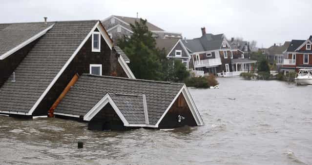 Floodwaters surround homes near the Mantoloking Bridge in Mantoloking, N.J. (Photo by Julio Cortez/Associated Press)
