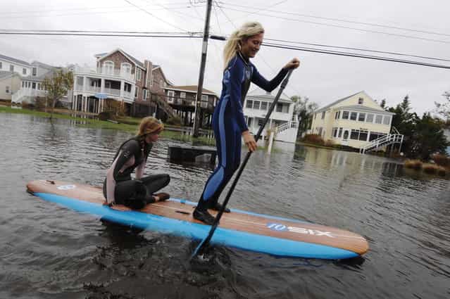 Jenna Webb (L), 18, and Zoe Jurusik, 20, paddle-board down a flooded city street in the aftermath of Hurricane Sandy in Bethany Beach, Delaware, October 30, 2012. Millions of people were left reeling in the aftermath of monster storm Sandy on Tuesday as New York City and a wide swathe of the eastern United States struggled with epic flooding and massive power outages. (Photo by Jonathan Ernst/Reuters)