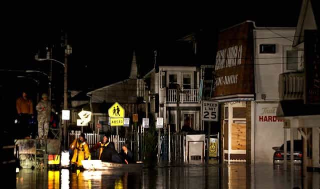 Rescue workers help stranded people out of their flooded homes in Seaside Heights, N.J. (Photo by Julio Cortez/Associated Press)