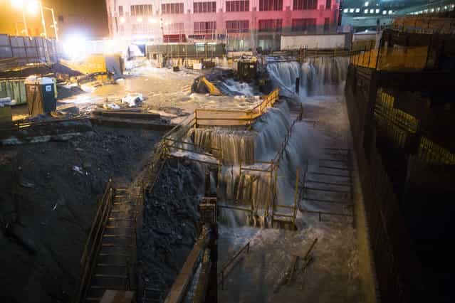 Sea water floods the Ground Zero construction site, Monday, October 29, 2012, in New York. Sandy continued on its path Monday, as the storm forced the shutdown of mass transit, schools and financial markets, sending coastal residents fleeing, and threatening a dangerous mix of high winds and soaking rain. (Photo by John Minchillo/AP Photo)