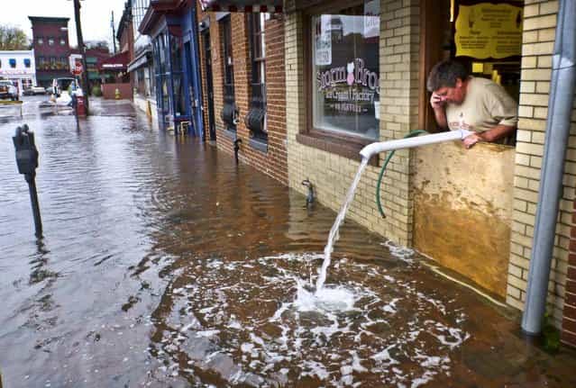 Sveinn Storm pumps water out of his flooded Storm Bros. Ice Cream Factory store in downtown Annapolis, Maryland. (Photo by Blake Sell/Associated Press)