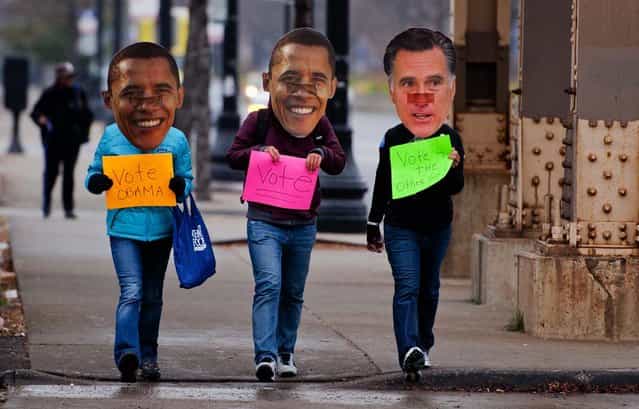 Three Obama supporters walk around the south side of Chicago, IL, November 6, 2012 wearing Obama and Romney masks holding placards asking people to vote. Citizens around the United States head to the polls to vote on the country's next president including in Ohio, a state with 18 electoral votes, were the race between US President Barack Obama and Mitt Romney is very close. (Photo by Jim Watson/AFP Photo)
