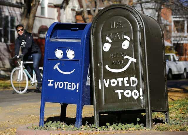 A biker passes by a pair of mailboxes in the Capitol Hill neighborhood November 6, 2012 in Denver, Colorado. Colorado is considered by most experts to be one of the key battleground state in this year's presidential election. (Photo by Marc Piscotty/AFP Photo)