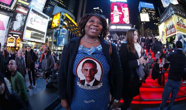 Marta Nunez from Honduras wears a Barack Obama dress as she watches TV screens in Times Square giving U.S presidential election results in New York November 6, 2012. (Photo by Carlo Allegri/Reuters)
