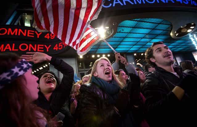 People in New York's Times Square celebrate the news that U.S. President Barack Obama won re-election on November 7, 2012. (Photo by Scott Eells/Bloomberg)