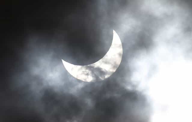 Clouds obscure the moon passing in front of the sun as it approaches a full solar eclipse in the northern Australian city of Cairns November 14, 2012. (Photo by Tim Wimborne/Reuters)