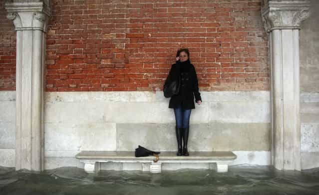 A woman stands on a bench above a flooded street during a period of seasonal high water in Venice November 11, 2012. The water level in the canal city rose to 149 cm (59 inches) above normal, according to the monitoring institute. (Photo by Manuel Silvestri/Reuters)