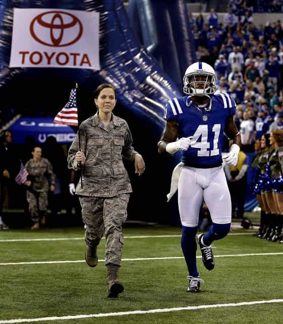 Indianapolis Colts free safety Antoine Bethea is escorted by a member of the military during introductions. (Photo by Darron Cummings/Associated Press)