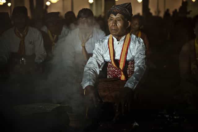 Javanese people pray before rituals night carnival [1st Suro] (Javanese calender) during Islamic New Year celebrations at Kasunanan Palace on November 14, 2012 in Solo City, Central Java, Indonesia. Javanese will celebrate the national holiday with ceremonies and rituals marking the 1434th Islamic New Year's Eve or [1st Suro]. The parade started from Keraton Kasunanan and is headed by a group of albino buffaloes, known as Kebo Bule. Local people believe that the parade of Heirlooms and Kebo Bule will bring them a better life. (Photo by Ulet Ifansasti)