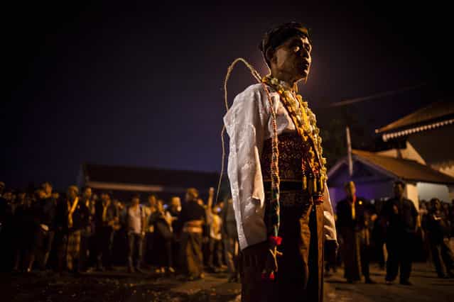A Javanese man stands during ritual [1st Suro] (Javanese calender) during Islamic New Year celebrations in Kasunanan Palace on November 15, 2012 in Solo City, Central Java, Indonesia. Javanese will celebrate the national holiday with ceremonies and rituals marking the 1434th Islamic New Year's Eve or [1st Suro]. The parade started from Keraton Kasunanan and is headed by a group of albino buffaloes, known as Kebo Bule. Local people believe that the parade of Heirlooms and Kebo Bule will bring them a better life. (Photo by Ulet Ifansasti)