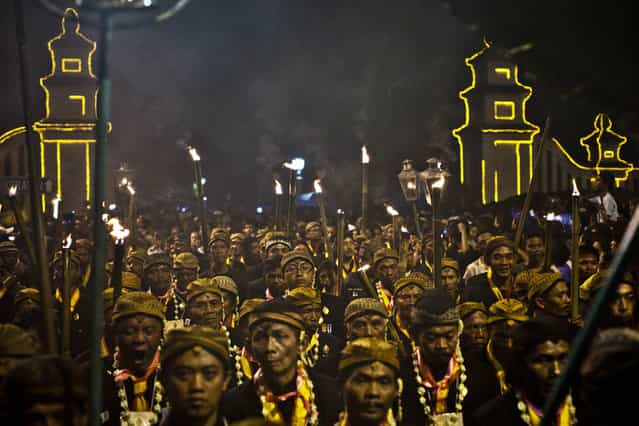 Javanese people walk on the rituals night carnival [1st Suro] ( Javanese calender) during Islamic New Year celebrations at Kasunanan Palace on November 15, 2012 in Solo City, Central Java, Indonesia. Javanese will celebrate the national holiday with ceremonies and rituals marking the 1434th Islamic New Year's Eve or [1st Suro]. The parade started from Keraton Kasunanan and is headed by a group of albino buffaloes, known as Kebo Bule. Local people believe that the parade of Heirlooms and Kebo Bule will bring them a better life. (Photo by Ulet Ifansasti)