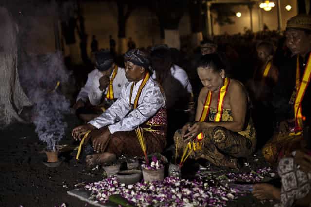 Javanese people pray before rituals night carnival [1st Suro] ( Javanese calender) during Islamic New Year celebrations at Kasunanan Palace on November 14, 2012 in Solo City, Central Java, Indonesia. Javanese will celebrate the national holiday with ceremonies and rituals marking the 1434th Islamic New Year's Eve or [1st Suro]. The parade started from Keraton Kasunanan and is headed by a group of albino buffaloes, known as Kebo Bule. Local people believe that the parade of Heirlooms and Kebo Bule will bring them a better life. (Photo by Ulet Ifansasti)