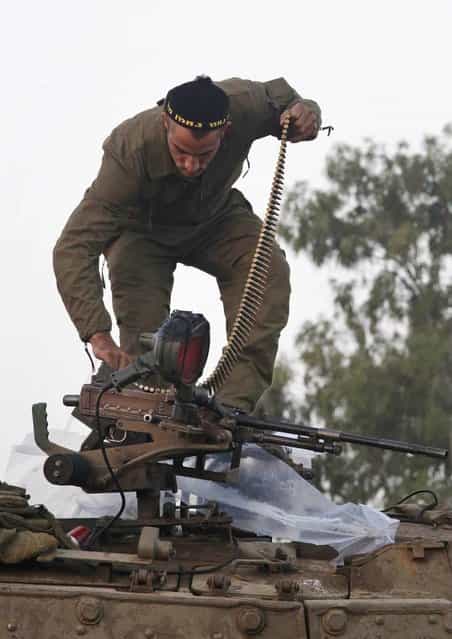 An Israeli soldier loads ammunition into a weapon atop a tank at a staging area near the Israel Gaza Strip Border, southern Israel, Tuesday, November 20, 2012. On Tuesday, grieving Gazans were burying militants and civilians killed in ongoing Israeli airstrikes, and barrages of rockets from Gaza sent terrified Israelis scurrying to take cover. Efforts to end a week-old convulsion of Israeli-Palestinian violence drew in the world's top diplomats Tuesday, with U.S. President Barack Obama dispatching his secretary of state to the region on an emergency mission and the U.N. chief appealing from Cairo for an immediate cease-fire. (Photo by Lefteris Pitarakis/AP Photo)