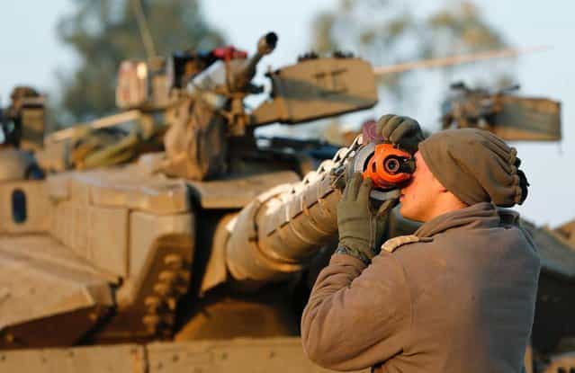 An Israeli soldier adjusts the barrel of a tank at a staging area near the border with central Gaza November 20, 2012. (Photo by Darren Whiteside/Reuters)