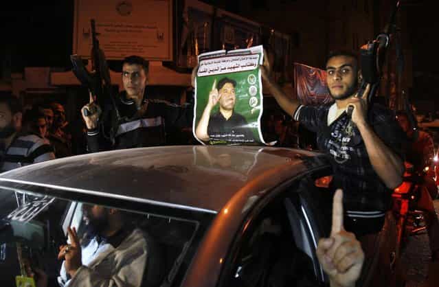 Palestinian gunmen hold a poster of late Ahmed Jabari, head of the Hamas military wing in Gaza City, while they celebrate the cease-fire agreement between Israel and Hamas in Gaza City, Wednesday, November 21, 2012. Israel and the Hamas militant group agreed to a cease-fire Wednesday to end eight days of the fiercest fighting in nearly four years, promising to halt attacks on each other and ease an Israeli blockade constricting the Gaza Strip. (Photo by Adel Hana/AP)
