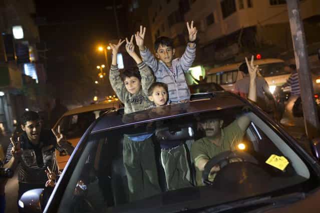 Palestinians celebrate the cease fire agreement between Israel and Hamas in Gaza City, Wednesday, November 21, 2012. Israel and the Hamas militant group agreed to a cease-fire Wednesday to end eight days of the fiercest fighting in nearly four years, promising to halt attacks on each other and ease an Israeli blockade constricting the Gaza Strip. (Photo by Adel Hana/AP)