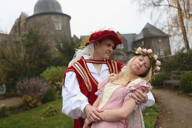 HOFGEISMAR, GERMANY - NOVEMBER 18: Prince Charming, actually actor Andreas Richhardt, supports Sleeping Beauty, played by actress Elisabeth Knoche, at Sababurg Palace on November 18, 2012 near Hofgeismar, Germany. Sleeping Beauty (in German: Dornroeschen) is one of the many stories featured in the collection of fairy tales collected by the Grimm brothers, and the 200th anniversary of the first publication of the stories will take place this coming December 20th. Andreas and Elisabeth perform a skit based on the Sleeping Beauty tale to visitors during the summer months at Sababurg, which is now a hotel called Dornroeschenschloss Sababurg and is located along the [Fairy Tale Road] ([Maerchenstrasse]) from where many of the tales derive. The Grimm brothers collected their stories from oral traditions in the region between Frankfurt and Bremen in the early 19th century, and the works include such global classics as Rapunzel, Little Red Riding Hood, The Pied Piper of Hamelin, Cinderella and Hansel and Gretel. (Photo by Sean Gallup)