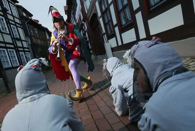 The Pied Piper of Hamelin, actually city tourism employee Michael Boyer, leads local children dressed as rats through a quiet street on November 19, 2012 in Hameln, Germany. The Pied Piper (in German: Der Rattenfaenger), is one of the many stories featured in the collection of fairy tales collected by the Grimm brothers, and the 200th anniversary of the first publication of the stories will take place this coming December 20th. Boyer, a U.S. citizen who has lived in Hameln for 15 years, and city children regularly perform a reenactment of the Pied Piper tale throughout the summer months. The Grimm brothers collected their stories from oral traditions in the region between Frankfurt and Bremen in the early 19th century, and the works include such global classics as Sleeping Beauty, Little Red Riding Hood, Rapunzel, Cinderella and Hansel and Gretel. (Photo by Sean Gallup)