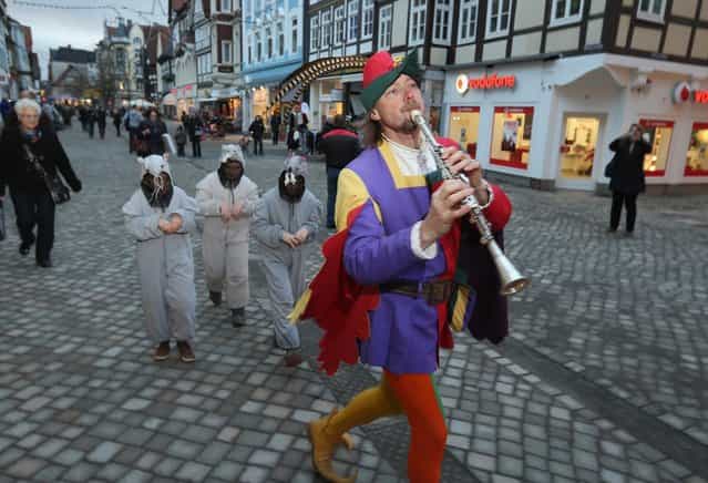 The Pied Piper of Hamelin, actually city tourism employee Michael Boyer, leads local children dressed as rats through a pedestrian shopping street on November 19, 2012 in Hameln, Germany. The Pied Piper (in German: Der Rattenfaenger), is one of the many stories featured in the collection of fairy tales collected by the Grimm brothers, and the 200th anniversary of the first publication of the stories will take place this coming December 20th. Boyer, a U.S. citizen who has lived in Hameln for 15 years, and city children regularly perform a reenactment of the Pied Piper tale throughout the summer months. The Grimm brothers collected their stories from oral traditions in the region between Frankfurt and Bremen in the early 19th century, and the works include such global classics as Sleeping Beauty, Little Red Riding Hood, Rapunzel, Cinderella and Hansel and Gretel. (Photo by Sean Gallup)