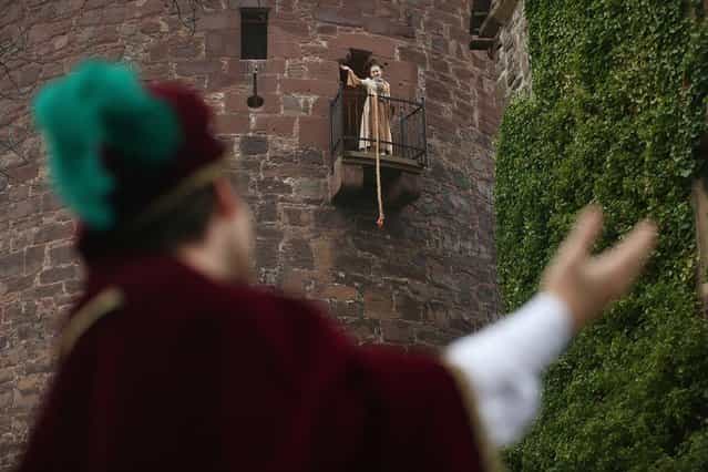 Rapunzel, actually 13-year-old actress Anna Helver, prepares to let down her hair to her prince, played by actor Daniel Stuebe, from a tower balcony of Trendelburg Castle on November 18, 2012 in Trendelburg, Germany. Rapunzel is one of the many stories featured in the collection of fairy tales collected by the Grimm brothers, and the 200th anniversary of the first publication of the stories will take place this coming December 20th. Anna and another actor perform a skit based on the Rapunzel tale to visitors at Trendelburg Castle, which is now a hotel, every Sunday. The Grimm brothers collected their stories from oral traditions in the region between Frankfurt and Bremen in the early 19th century, and the works include such global classics as Sleeping Beauty, Little Red Riding Hood, The Pied Piper of Hamelin, Cinderella and Hansel and Gretel. (Photo by Sean Gallup)