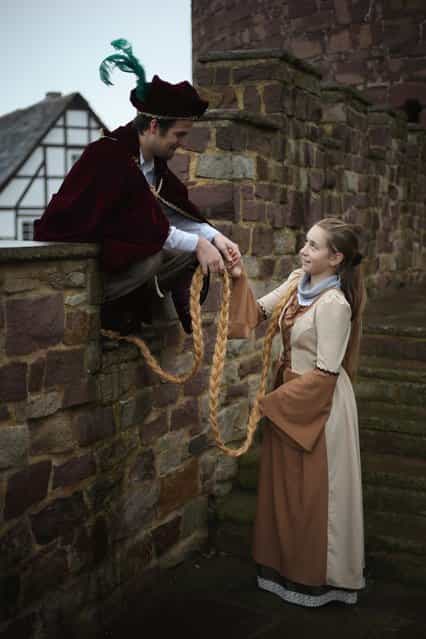 Rapunzel, actually 13-year-old actress Anna Helver, greets her prince, played by actor Daniel Stuebe, on a rampart of Trendelburg Castle on November 18, 2012 in Trendelburg, Germany. Rapunzel is one of the many stories featured in the collection of fairy tales collected by the Grimm brothers, and the 200th anniversary of the first publication of the stories will take place this coming December 20th. Anna and another actor perform a skit based on the Rapunzel tale to visitors at Trendelburg Castle, which is now a hotel, every Sunday. The Grimm brothers collected their stories from oral traditions in the region between Frankfurt and Bremen in the early 19th century, and the works include such global classics as Sleeping Beauty, Little Red Riding Hood, The Pied Piper of Hamelin, Cinderella and Hansel and Gretel. (Photo by Sean Gallup)