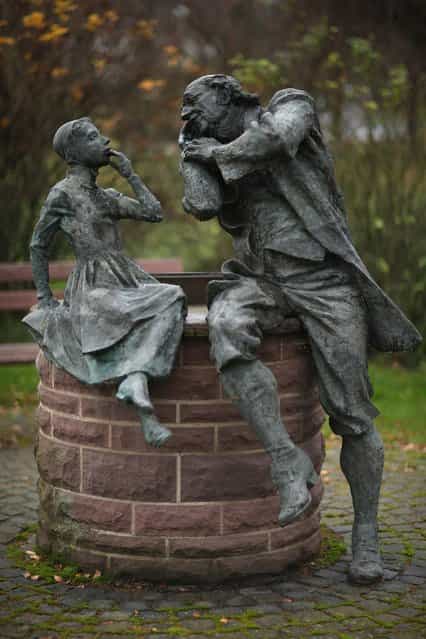 A bronze sculpture depicts a grandfather recounting a fairy tale to his dranddaughter on November 19, 2012 in Schoeneberg, Germany. Schoeneberg lies along the [Fairy Tale Road] (in German: Die Maerchenstrasse) that leads through the region between Frankfurt and Bremen where the Grimm brothers collected and adapted most of their fairy tales, which include such global classics as Sleeping Beauty, Little Red Riding Hood, Rapunzel, Cinderella and Hansel and Gretel, in the early 19th century. The 200th anniversary of the first publication of the stories will take place this coming December 20th. (Photo by Sean Gallup)