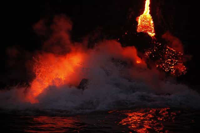 Waves crash over lava as it flows into the ocean near Volcanoes National Park in Kalapana, Hawaii on November 27, 2012. A volcano on Hawaii's largest island is spilling lava into the ocean, creating a rare and spectacular fusion of steam and waves that officials said on Tuesday could attract thrill seeking visitors if it continues. (Photo by Hugh Gentry/Reuters)