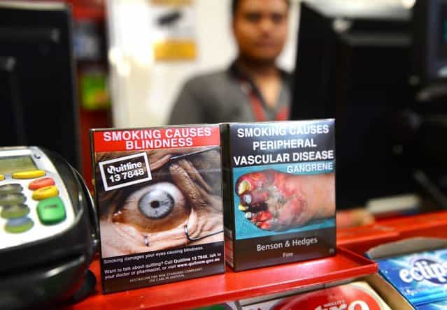 Packaged cigarettes which have to be sold in identical olive-brown packets bearing the same typeface and largely covered with graphic health warnings, with the same style of writing so the only identifier of a brand will be the name on the packet, are displayed in a shop in Sydney on December 1, 2012. A new world-first law forcing tobacco companies to sell cigarettes in identical packets came into effect Saturday in Australia in an effort to strip any glamour from smoking and prevent young people from taking up the habit. (Photo by William West/AFP Photo)