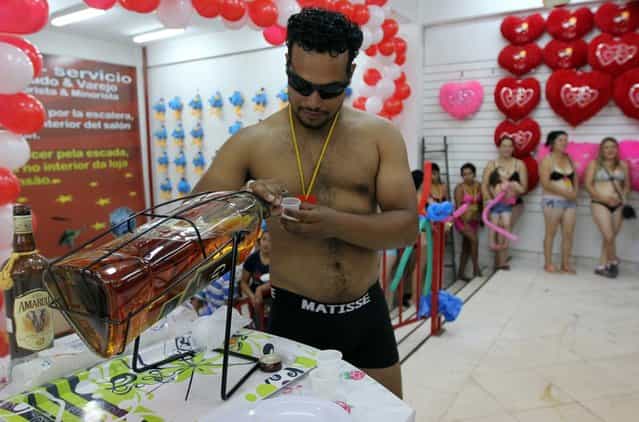 A customer in underwear tastes a whiskey during a special promotion at a mall in Ciudad del Este, Paraguay, on December 2, 2012. AFP PHOTO/ JOSE ESPINOLA (Photo credit should read JOSE ESPINOLA/AFP/Getty Images)