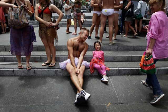 Dancer Travis De Vries chats to a young fan prior to the [AIME Strut the Streets] an attempt to break the Guiness record for the world's largest swimwear parade on December 7, 2012 in Sydney, Australia. The event was organised to raise funds and awareness for the not for profit charity organisation, the Australian Indigenous Mentoring Experience. (Photo by Lisa Maree Williams)
