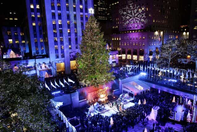 The Rockefeller Center Christmas tree is lit during the 80th annual tree lighting ceremony at Rockefeller Center in New York. (Photo by Kathy Willens/Associated Press)