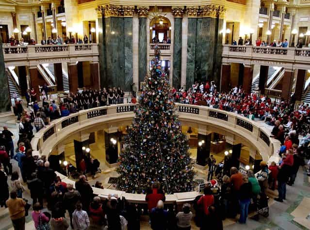 Fourth-graders from Medford Elementary and Stetsonville Elementary schools perform during a Christmas tree lighting ceremony at the State Capitol in Madison, Wisconsin. (Photo by Scott Bauer/Associated Press)