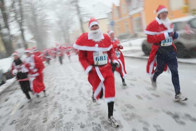 Participants dressed as Santa Claus run through falling snow in the 4th annual Michendorf Santa Run (Michendorfer Nikolauslauf) on December 9, 2012 in Michendorf, Germany. Over 800 people took part in this year's races that included children's and adults' races. (Photo by Sean Gallup)