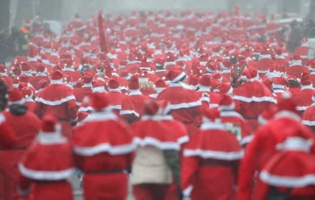 Participants dressed as Santa Claus run in the 4th annual Michendorf Santa Run (Michendorfer Nikolauslauf) on December 9, 2012 in Michendorf, Germany. Over 800 people took part in this year's races that included children's and adults' races. (Photo by Sean Gallup)