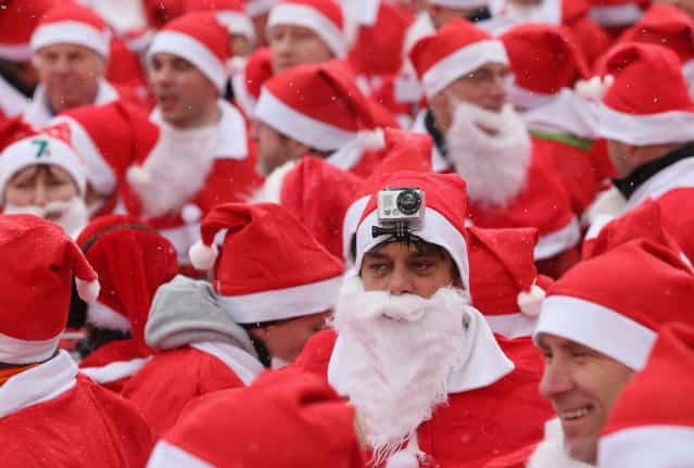 Participants dressed as Santa Claus, including one with a GoPro camera on his head, gather shortly before the 4th annual Michendorf Santa Run (Michendorfer Nikolauslauf) on December 9, 2012 in Michendorf, Germany. Over 800 people took part in this year's races that included children's and adults' races. (Photo by Sean Gallup)